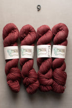 Load image into Gallery viewer, Four skeins of red yarn with labels on a gray background