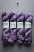 Load image into Gallery viewer, Five skeins of purple yarn with labels on a gray background