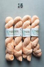 Load image into Gallery viewer, Four skeins of light pink yarn with labels on a gray background
