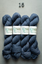 Load image into Gallery viewer, Four skeins of blue yarn with labels on a gray background