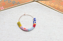 Load image into Gallery viewer, Colorful beaded hoop on a textured fabric background