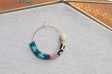 Load image into Gallery viewer, Colorful beaded necklace on a textured surface with a patterned background