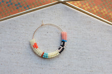 Load image into Gallery viewer, Beaded hoop earring on a textured surface with a colorful background