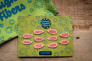 Green card with colorful text and logos on a wooden surface
