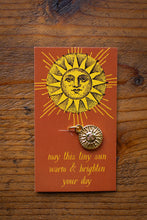 Load image into Gallery viewer, Sun-shaped pendant on a card with text on a wooden surface