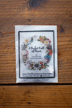 Load image into Gallery viewer, Packaging of 'A Pocket Full of Roses' on a wooden surface