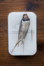 Load image into Gallery viewer, Small rectangular tin with a bird illustration on a wooden surface
