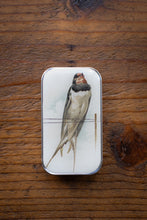 Load image into Gallery viewer, Small rectangular tin with a bird illustration on a wooden surface