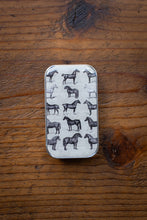 Load image into Gallery viewer, Small rectangular tin with horse illustrations on a wooden surface