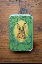 Load image into Gallery viewer, Small tin box with a rabbit illustration on a wooden surface