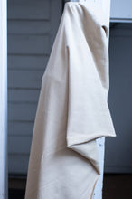 Load image into Gallery viewer, Beige towel hanging on a white pole against a gray wall.