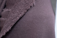 Load image into Gallery viewer, Close-up of a textured fabric with a frayed edge on a plain background