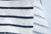 Load image into Gallery viewer, Close-up of a white fabric with black horizontal stripes and decorative edge.