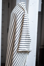 Load image into Gallery viewer, Striped shirt hanging on a white door