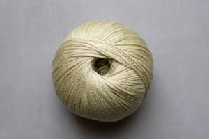 Ball of beige yarn on a gray background