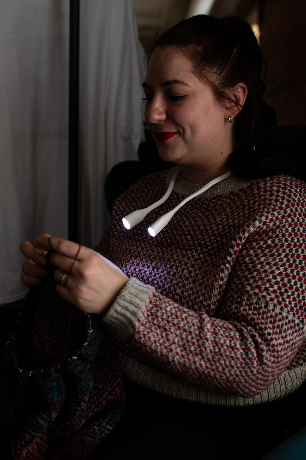 person knitting using hoodie lights