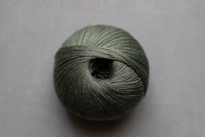 Ball of green yarn on a gray background