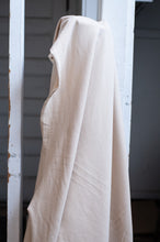 Load image into Gallery viewer, Beige fabric draped over a white metal frame against a neutral background