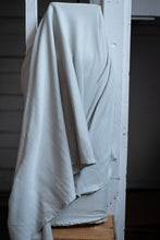 Load image into Gallery viewer, Light gray fabric draped over a white wooden frame against a dark background