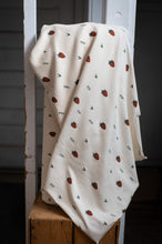 Load image into Gallery viewer, White blanket with strawberry pattern draped over a wooden ladder against a dark background