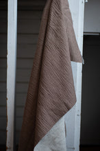 Load image into Gallery viewer, Brown textured blanket draped over a white wooden door