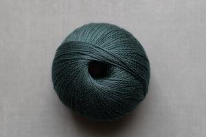 Teal skein of yarn on a light gray background