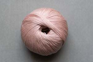 Ball of pink yarn on a gray background