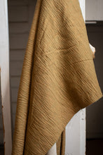 Load image into Gallery viewer, Brown textured fabric draped over a white wooden surface