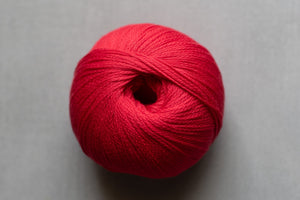 Red ball of yarn on a gray background