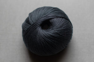 Ball of dark blue yarn on a gray background