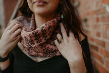 Load image into Gallery viewer, Person wearing a patterned scarf with a blurred brick wall background