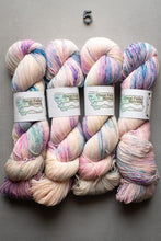 Load image into Gallery viewer, Four skeins of multicolored yarn with 'Great Falls Yarn' labels on a gray background.