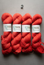 Load image into Gallery viewer, Four skeins of red yarn with labels on a gray background