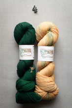 Load image into Gallery viewer, Two skeins of yarn, one green and one beige, with labels on a gray background.