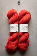 Load image into Gallery viewer, Two skeins of red yarn with labels on a gray background