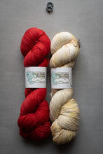 Load image into Gallery viewer, Two skeins of yarn, one red and one beige, with labels on a gray background.