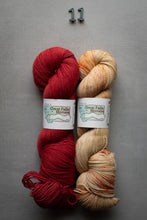 Load image into Gallery viewer, Two skeins of yarn, one red and one beige, with labels on a gray background.