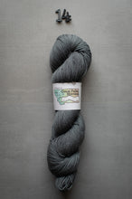 Load image into Gallery viewer, Gray skein of yarn with a label on a gray background