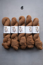 Load image into Gallery viewer, Five skeins of brown yarn with labels on a gray background