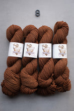 Load image into Gallery viewer, Four skeins of brown yarn with labels on a gray background