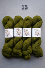 Load image into Gallery viewer, Four skeins of green yarn with labels on a gray background