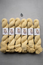 Load image into Gallery viewer, Six skeins of yellow yarn with labels on a gray background