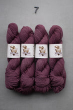 Load image into Gallery viewer, Four skeins of purple yarn with labels on a gray background