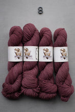 Load image into Gallery viewer, Four skeins of purple yarn with labels on a gray background