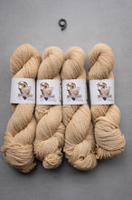 Load image into Gallery viewer, Four skeins of beige yarn with labels on a gray background