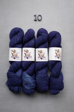 Load image into Gallery viewer, Four skeins of blue yarn with labels on a gray background