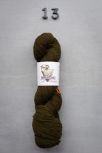 Load image into Gallery viewer, Brown skein of yarn with a label on a gray background