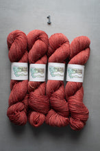 Load image into Gallery viewer, Four skeins of red yarn with labels on a gray background