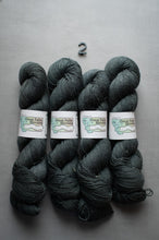 Load image into Gallery viewer, Four skeins of dark gray yarn with labels on a gray background