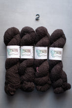 Load image into Gallery viewer, Dark brown yarn skeins with labels on a gray background